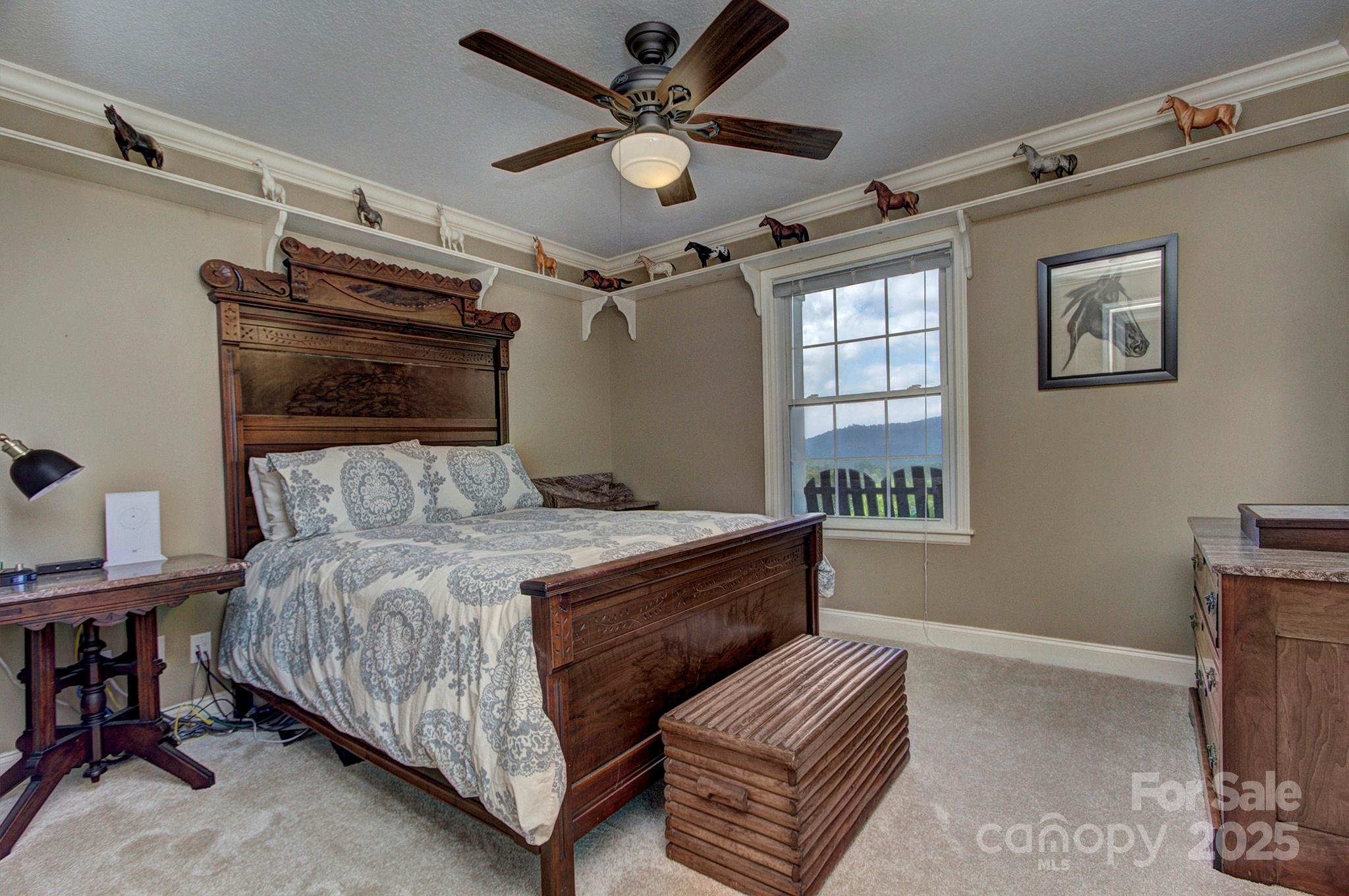 193 Duncan Creek Road Fletcher, NC 28732 - Photo 35 of 48 a bedroom with a bed and a chandelier