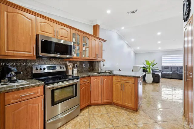 a kitchen with stainless steel appliances granite countertop a stove a sink and a microwave