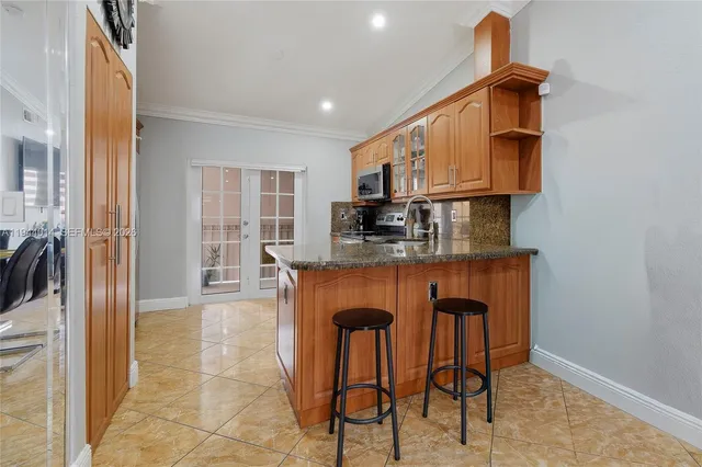 a kitchen with stainless steel appliances granite countertop a stove a sink and a refrigerator