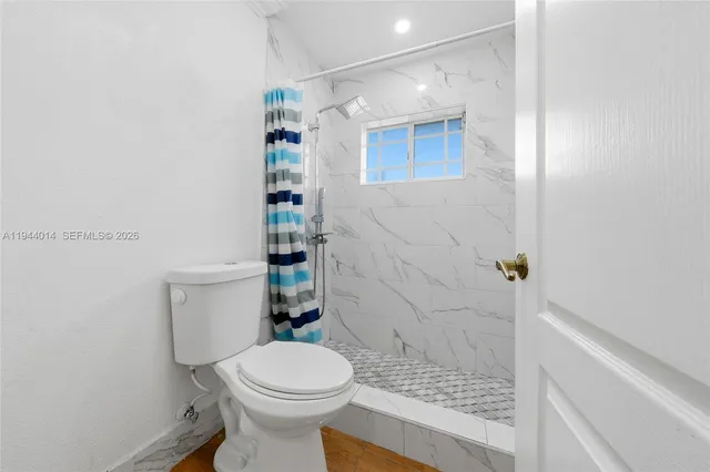 a bathroom with a toilet and a shower