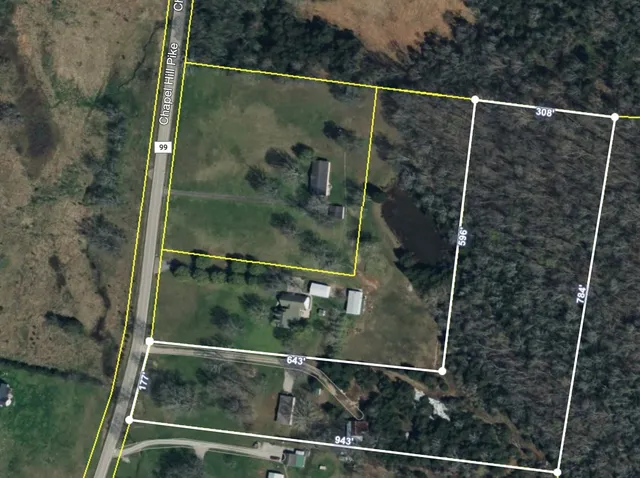 a view of a field with trees in background