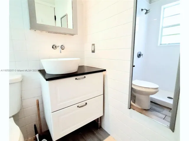 a bathroom with a toilet a sink and a mirror