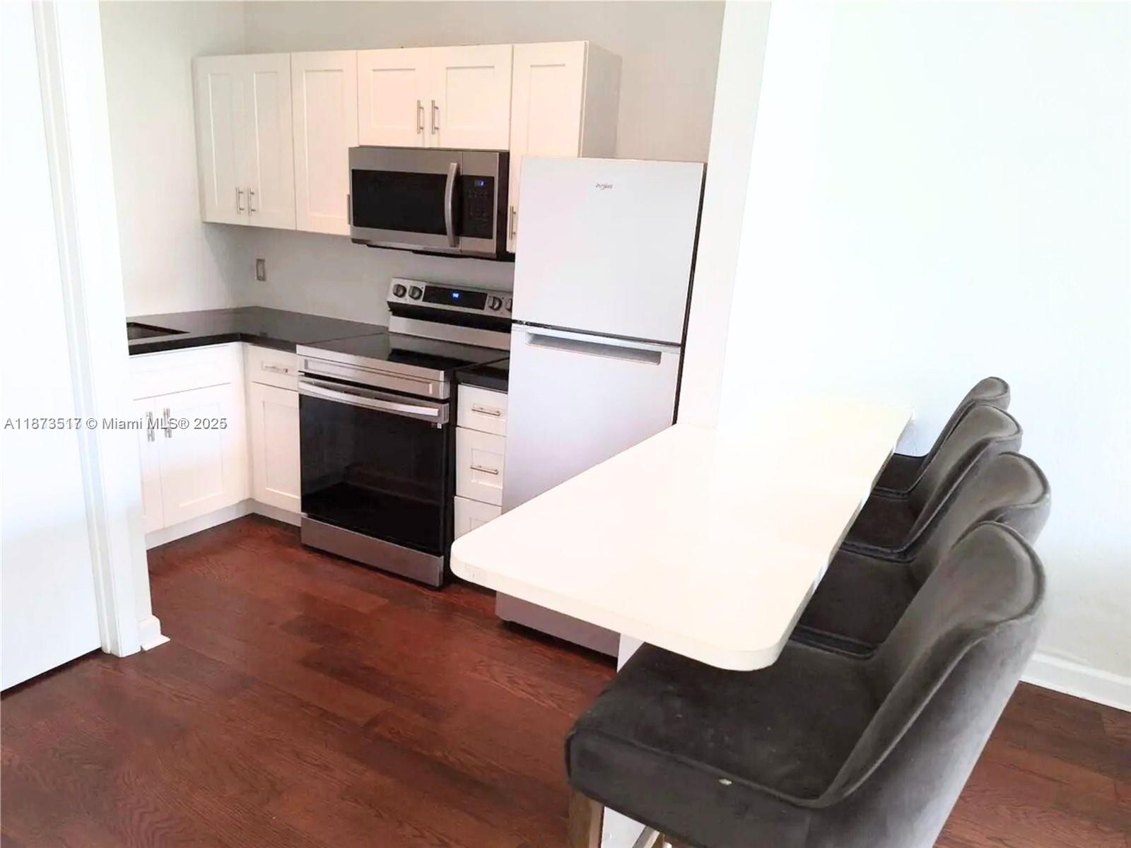 1009 Meridian Avenue, Unit 13 Miami Beach, FL 33139 - Photo 8 of 17 a kitchen with kitchen island a sink appliances and cabinets