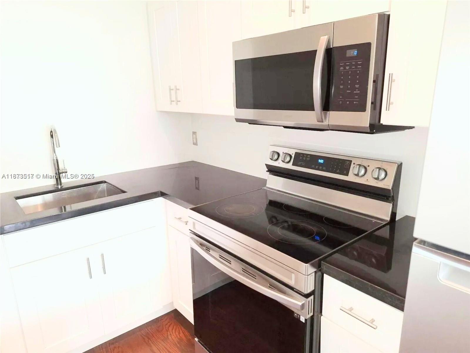 1009 Meridian Avenue, Unit 13 Miami Beach, FL 33139 - Photo 10 of 17 a kitchen with a stove and a microwave