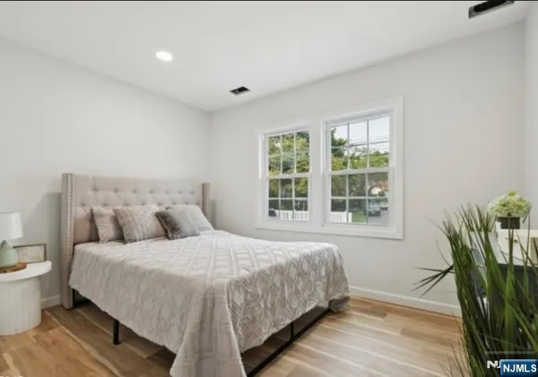 a bedroom with a large bed and a potted plant