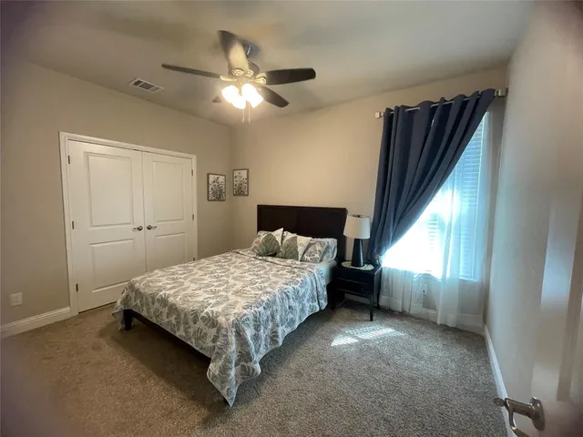 a spacious bedroom with a bed and a chandelier