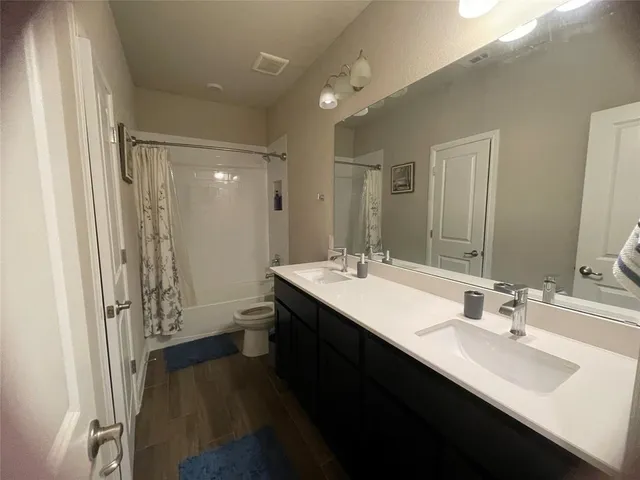 a bathroom with a double vanity sink a toilet and a mirror