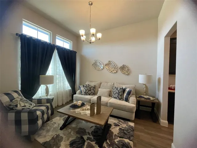 a living room with furniture a fireplace and a chandelier