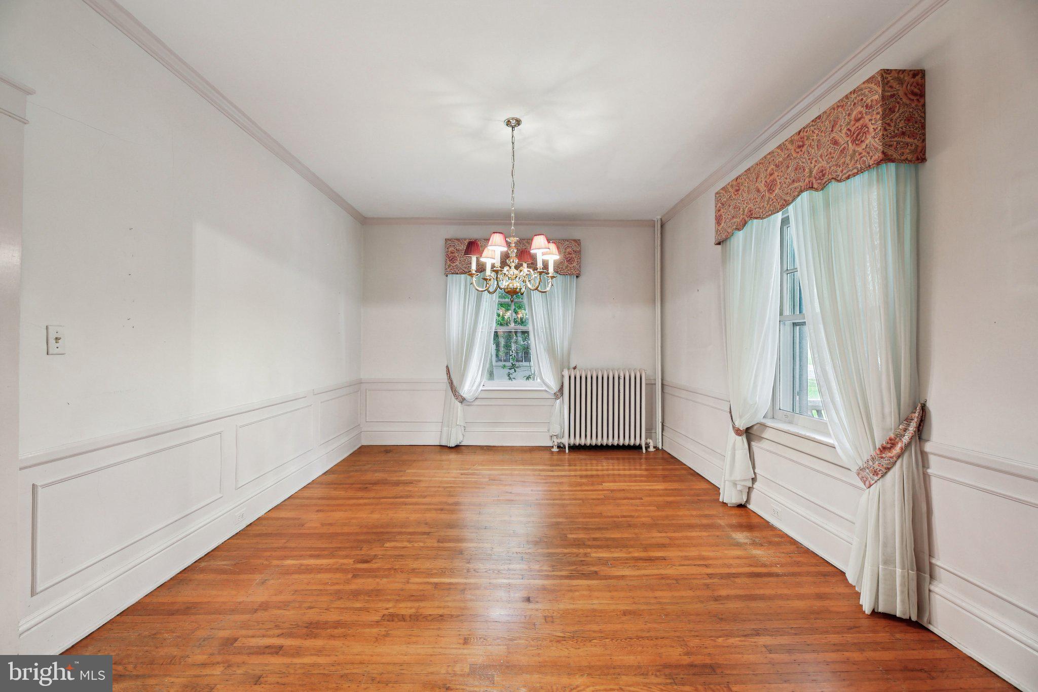 409 Cedarcroft Road Baltimore, MD 21212 - Photo 10 of 43 a view of an empty room with window and wooden floor