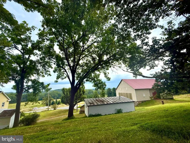 a view of a house with a yard garage and tree