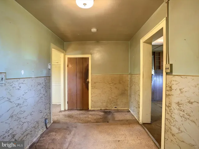 an empty room with closet and windows