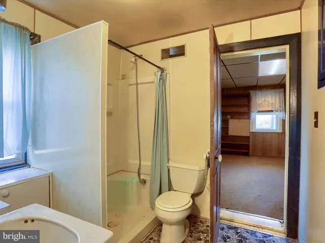 a view of an empty room with window and closet area