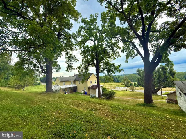 a view of a house with backyard and tree