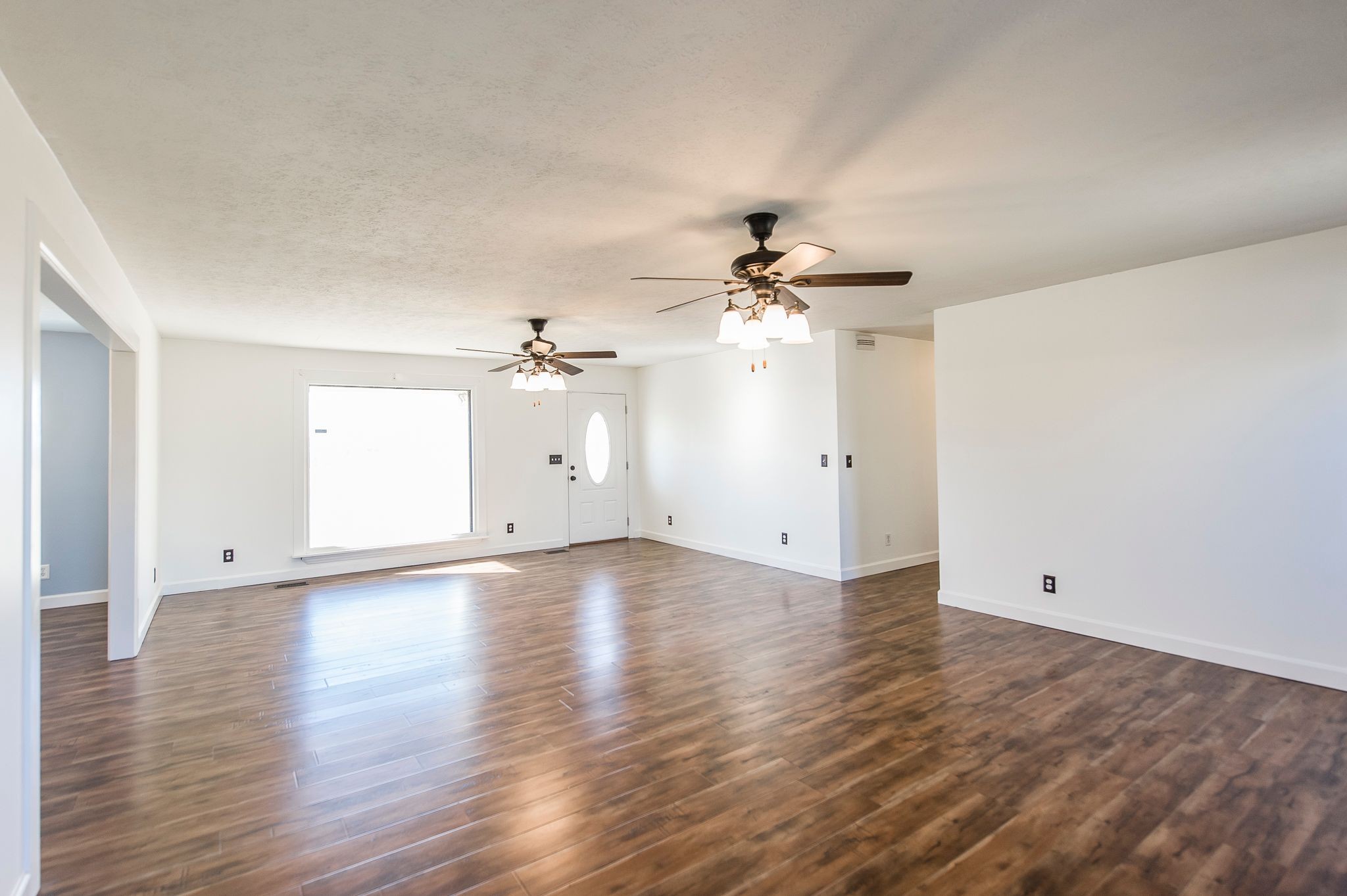 1881 Pinnacle Road Pleasant View, TN 37146 - Photo 6 of 62 an empty room with wooden floor chandelier fan and windows