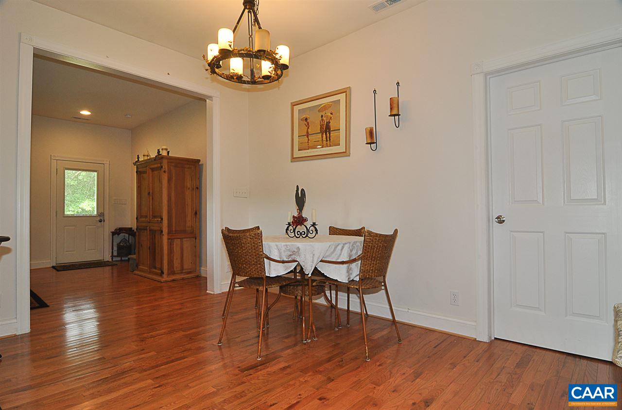 341 Grace Johnson Road Kents Store, VA 23084 - Photo 14 of 32 a dining room with wooden floor a chandelier a wooden table and chairs
