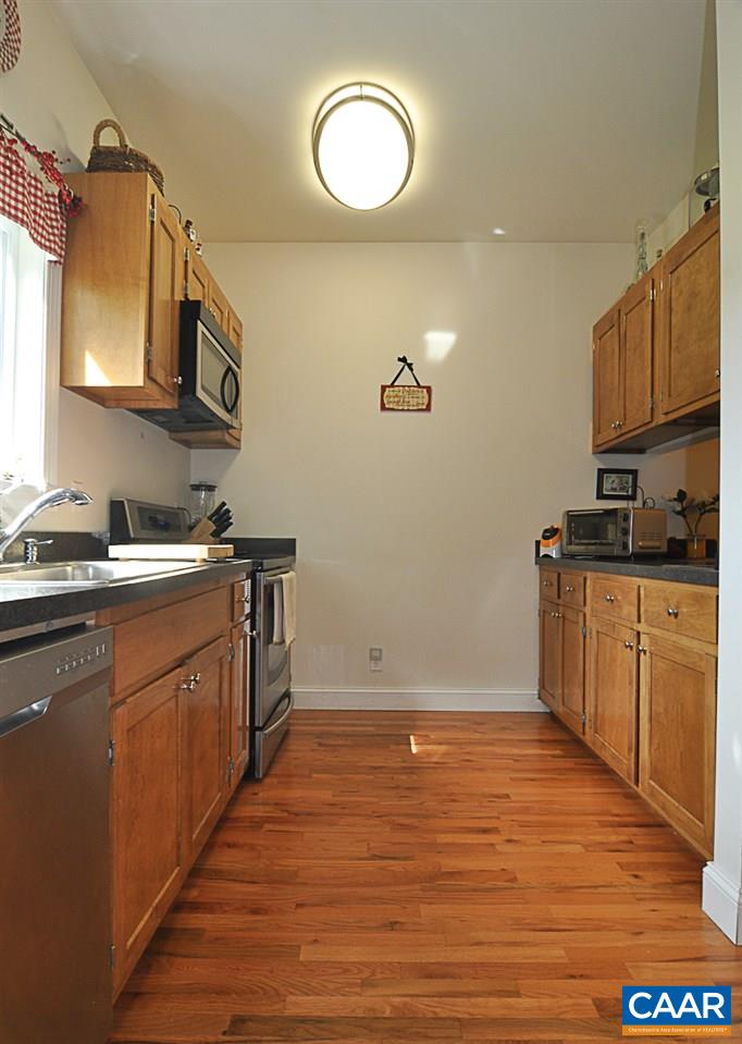 341 Grace Johnson Road Kents Store, VA 23084 - Photo 18 of 32 a kitchen with cabinets wooden floor and a stainless steel appliances