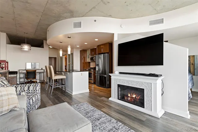 a living room with furniture a flat screen tv and a fireplace