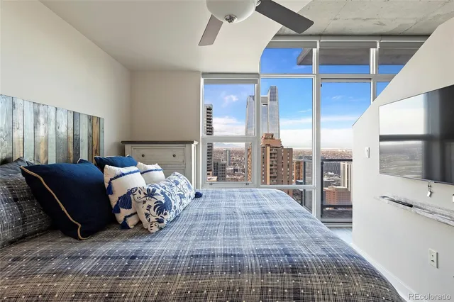 a bed sitting in a bedroom next to a window with balcony