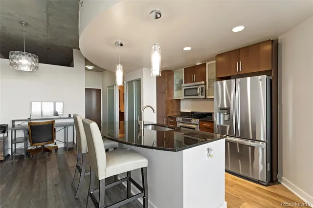 a kitchen with kitchen island a refrigerator and a stove top oven