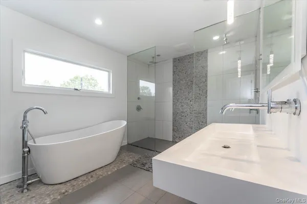 a spacious bathroom with a bathtub sink and a mirror