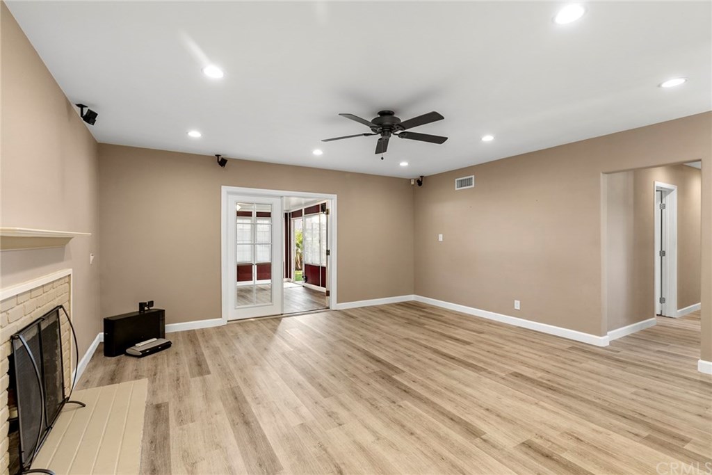 1350 North Devonshire Road Anaheim, CA 92801 - Photo 1 of 1 Living room with fireplace, surround sound speakers, ceiling fan and French Doors leading into Sunroom/Patio Room.