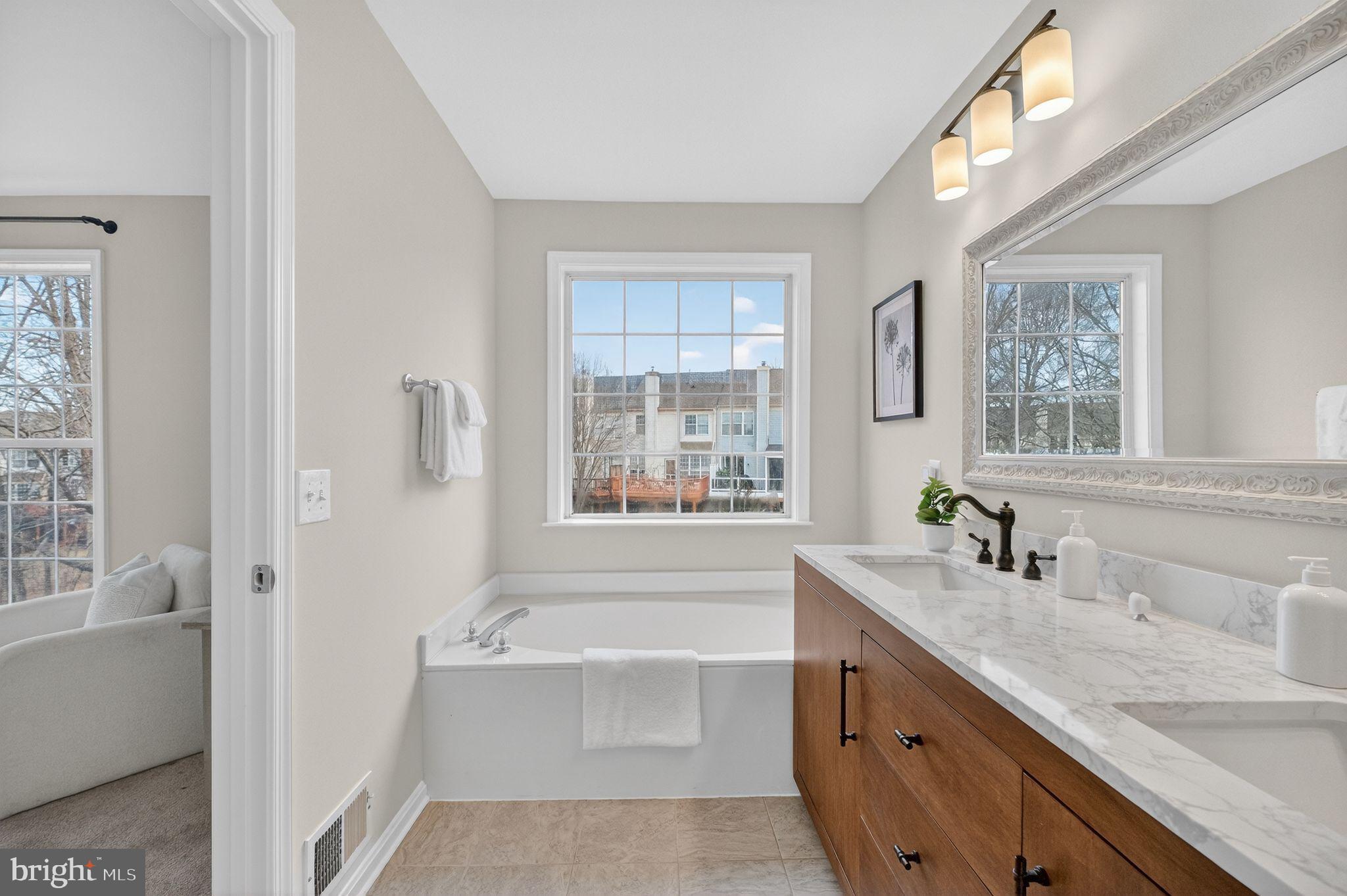 47610 Watkins Island Square Sterling, VA 20165 - Photo 25 of 48 a bathroom with a tub a sink and a window