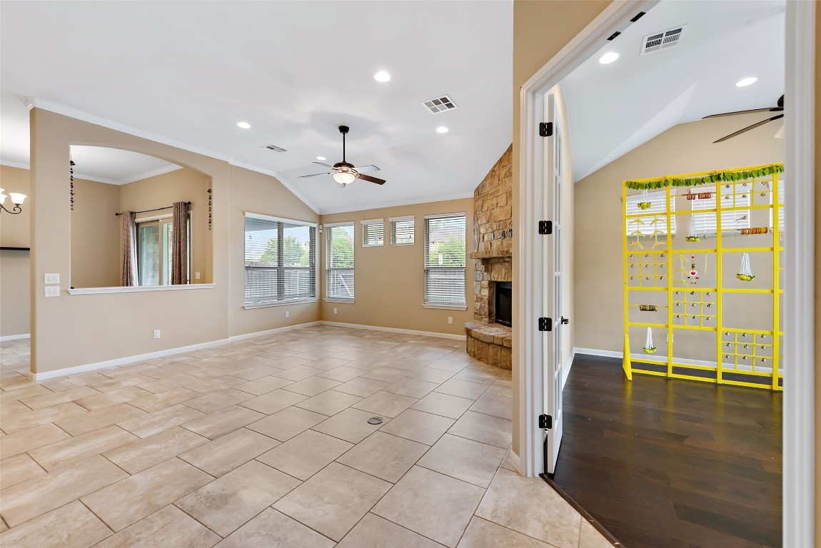 2000 Manada Trail Leander, TX 78641 - Photo 7 of 36 A spacious living area featuring a stone-accented fireplace and plentiful natural light.