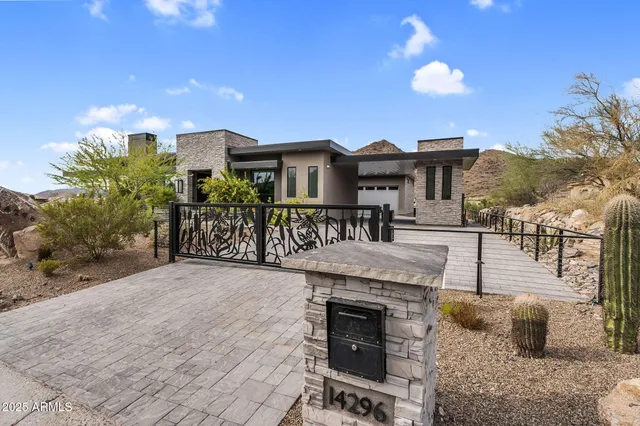 a view of an empty room with wooden floor and a fireplace
