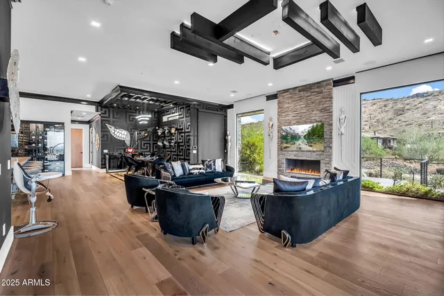 a living room with couches and kitchen view with wooden floor