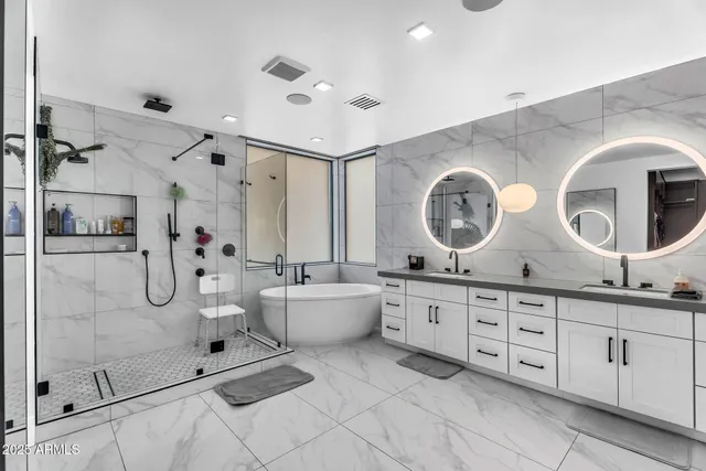 a spacious bedroom with a large bed and a chandelier