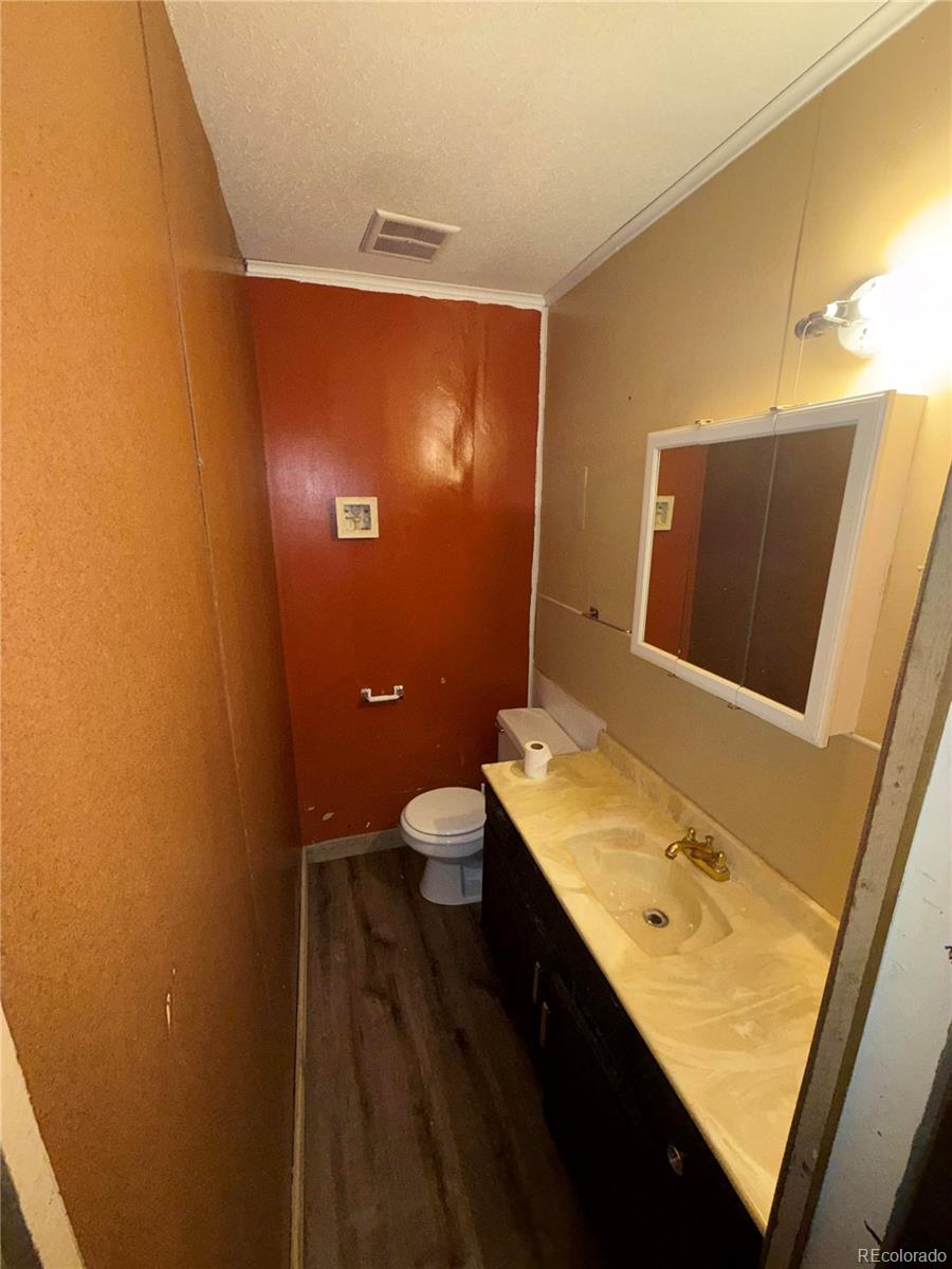 28894 Highway 24 Stratton, CO 80836 - Photo 14 of 41 a bathroom with a sink a toilet and mirror