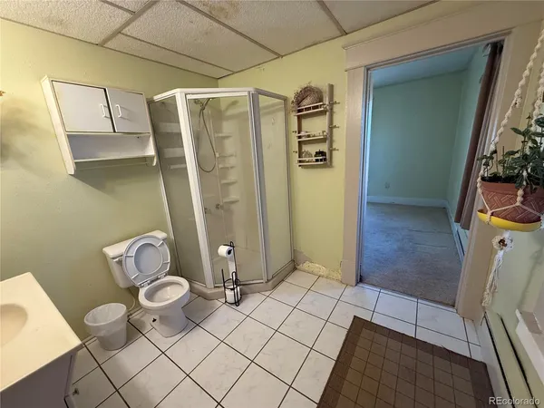 a bathroom with a granite countertop toilet sink and mirror