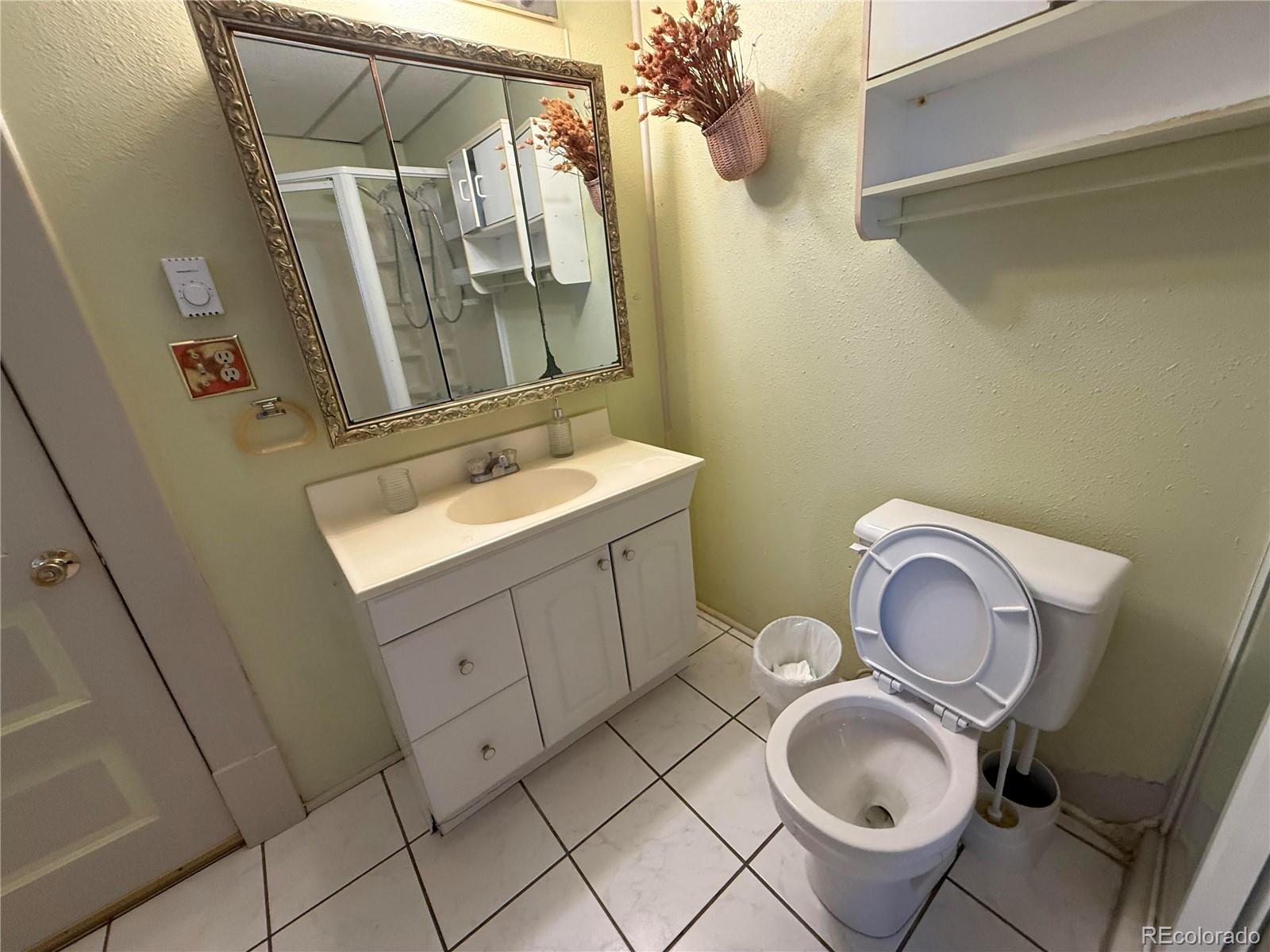28894 Highway 24 Stratton, CO 80836 - Photo 20 of 41 a bathroom with a granite countertop toilet sink and mirror