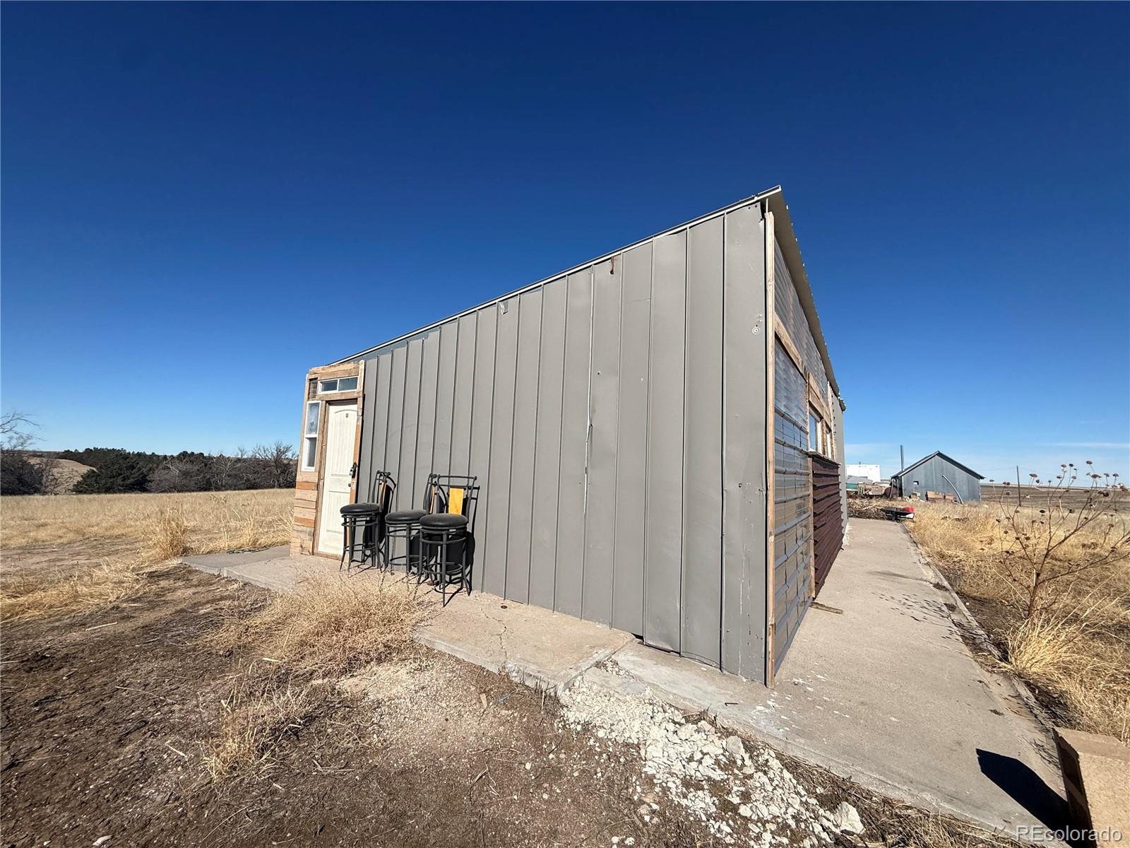 28894 Highway 24 Stratton, CO 80836 - Photo 36 of 41 a backyard of a house with lake view and a floor to ceiling window