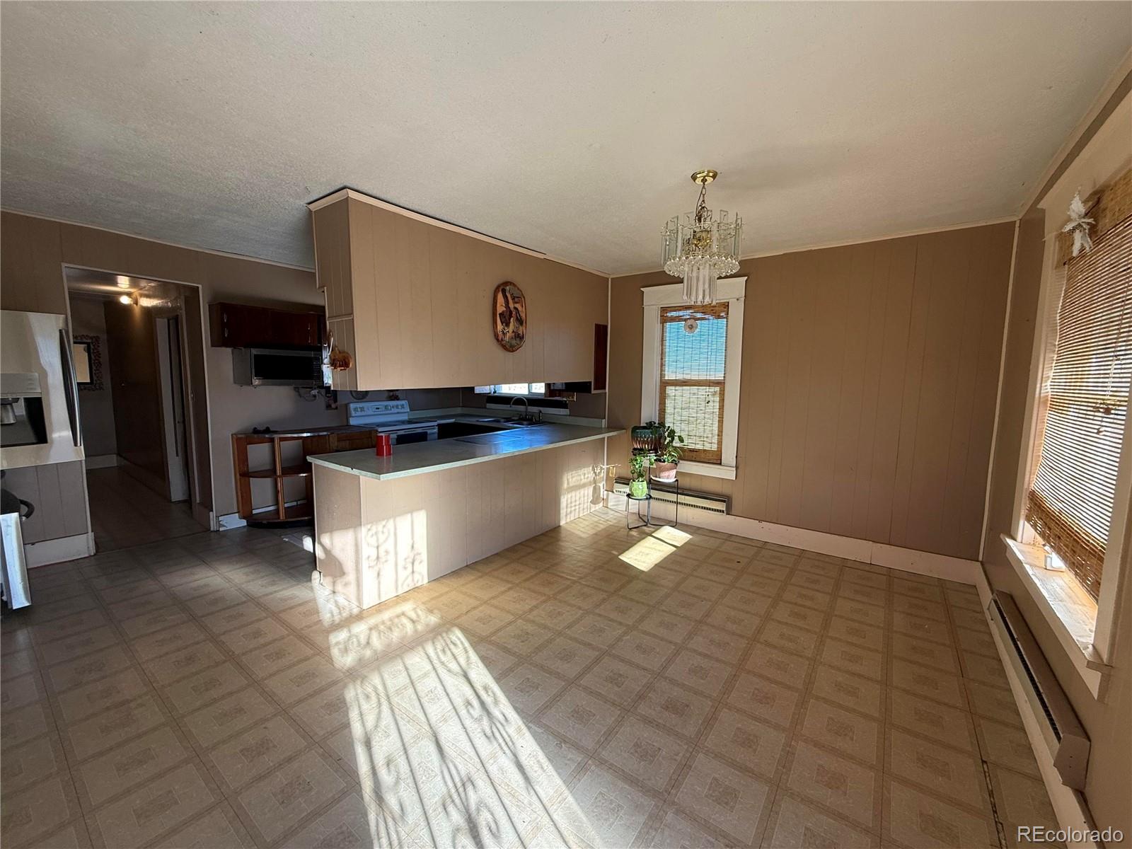 28894 Highway 24 Stratton, CO 80836 - Photo 9 of 41 a open kitchen with kitchen island granite countertop a refrigerator stove top oven and sink