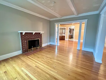 a view of an empty room with glass door and wooden floor