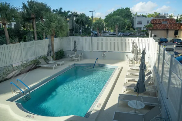 a view of a backyard with couches under an umbrella