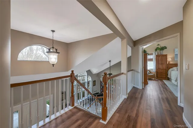 a view of a hallway with wooden floor and staircase