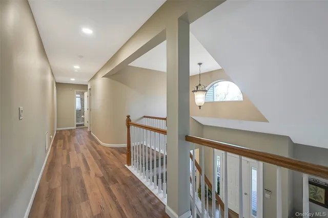 a view of a hallway with wooden floor and entryway