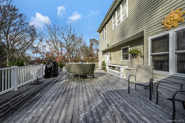 a balcony with wooden floor table and chairs