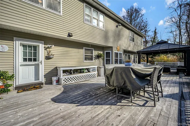 a view of a patio with table and chairs with wooden floor and fence