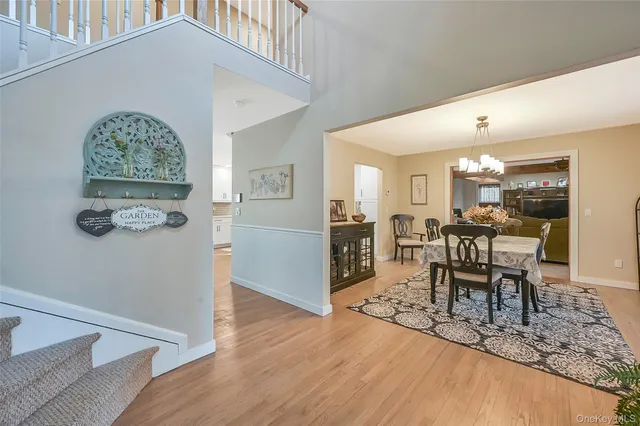 a dining room with wooden floor and a chandelier