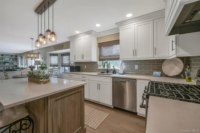a kitchen with granite countertop a sink a stove cabinets and a dining table