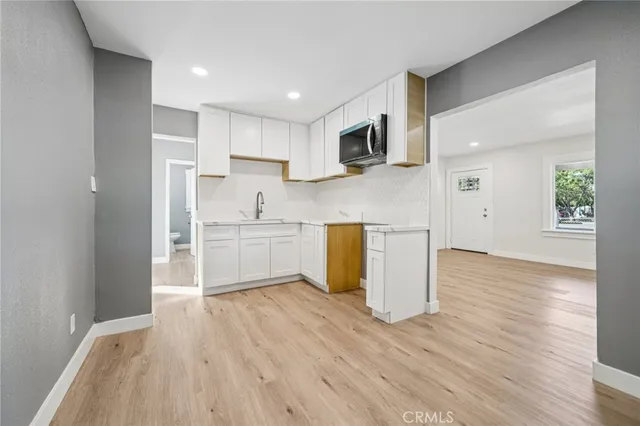 a view of a kitchen with wooden floor and electronic appliances