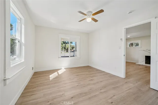 a view of empty room with wooden floor and window
