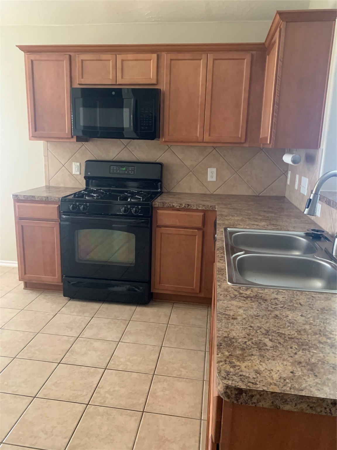 8823 Old Maple Lane Humble, TX 77338 - Photo 4 of 13 a kitchen with granite countertop a stove top oven microwave and cabinets