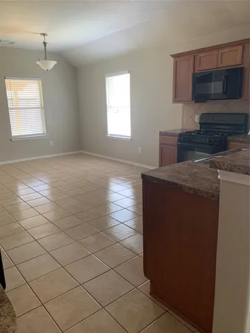 a kitchen with a sink a microwave and cabinets