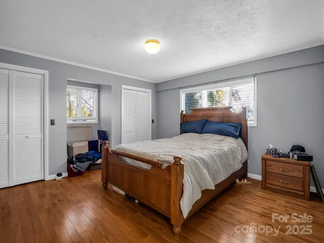 a bedroom with a bed and wooden floor
