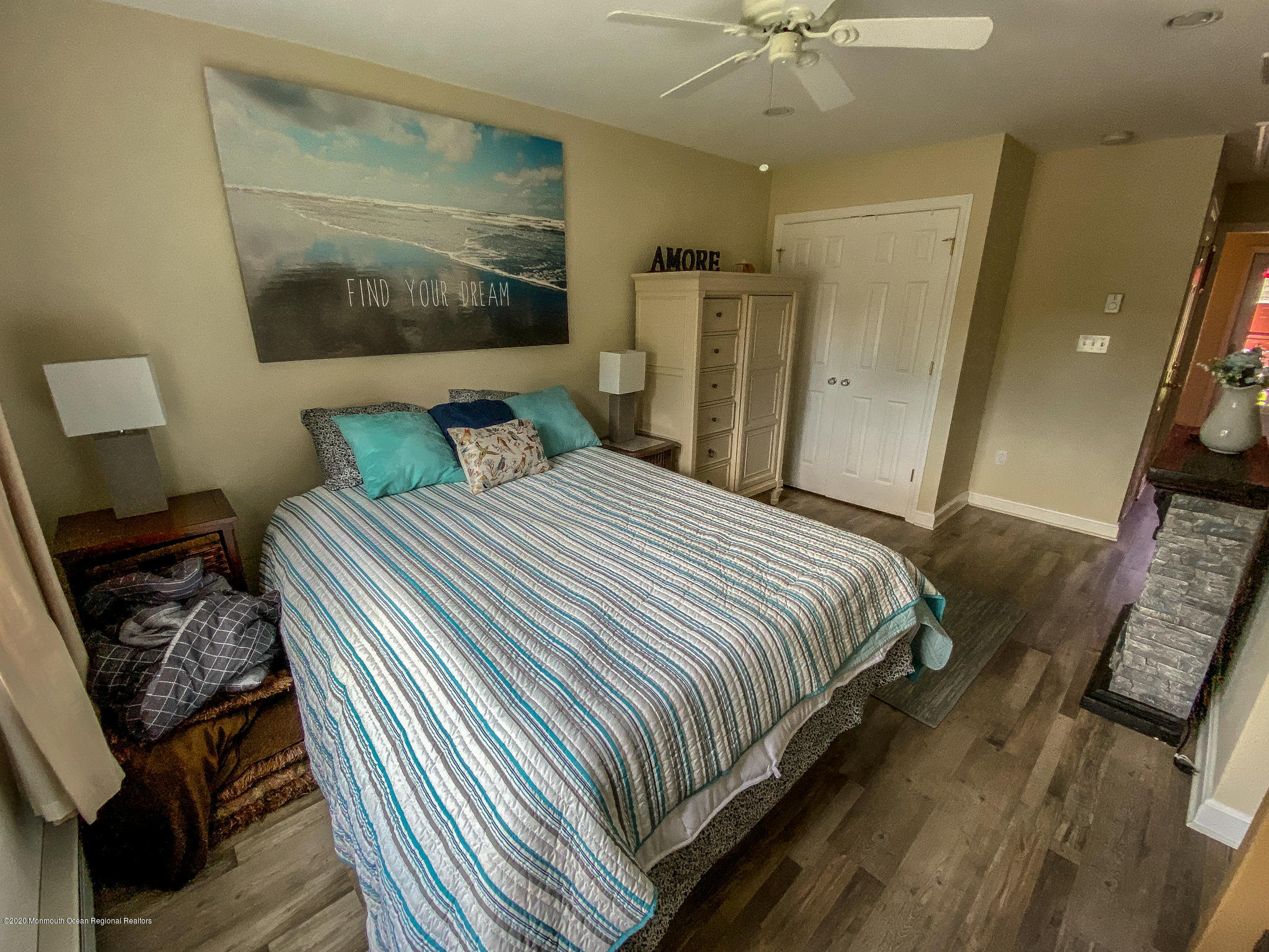 220 Wave Road Manahawkin, NJ 08050 - Photo 55 of 87 a bedroom with a bed and a chandelier