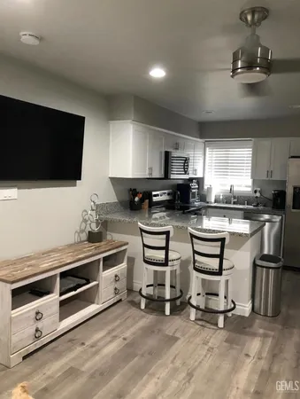 a kitchen with stainless steel appliances a stove a sink a microwave a refrigerator and cabinets